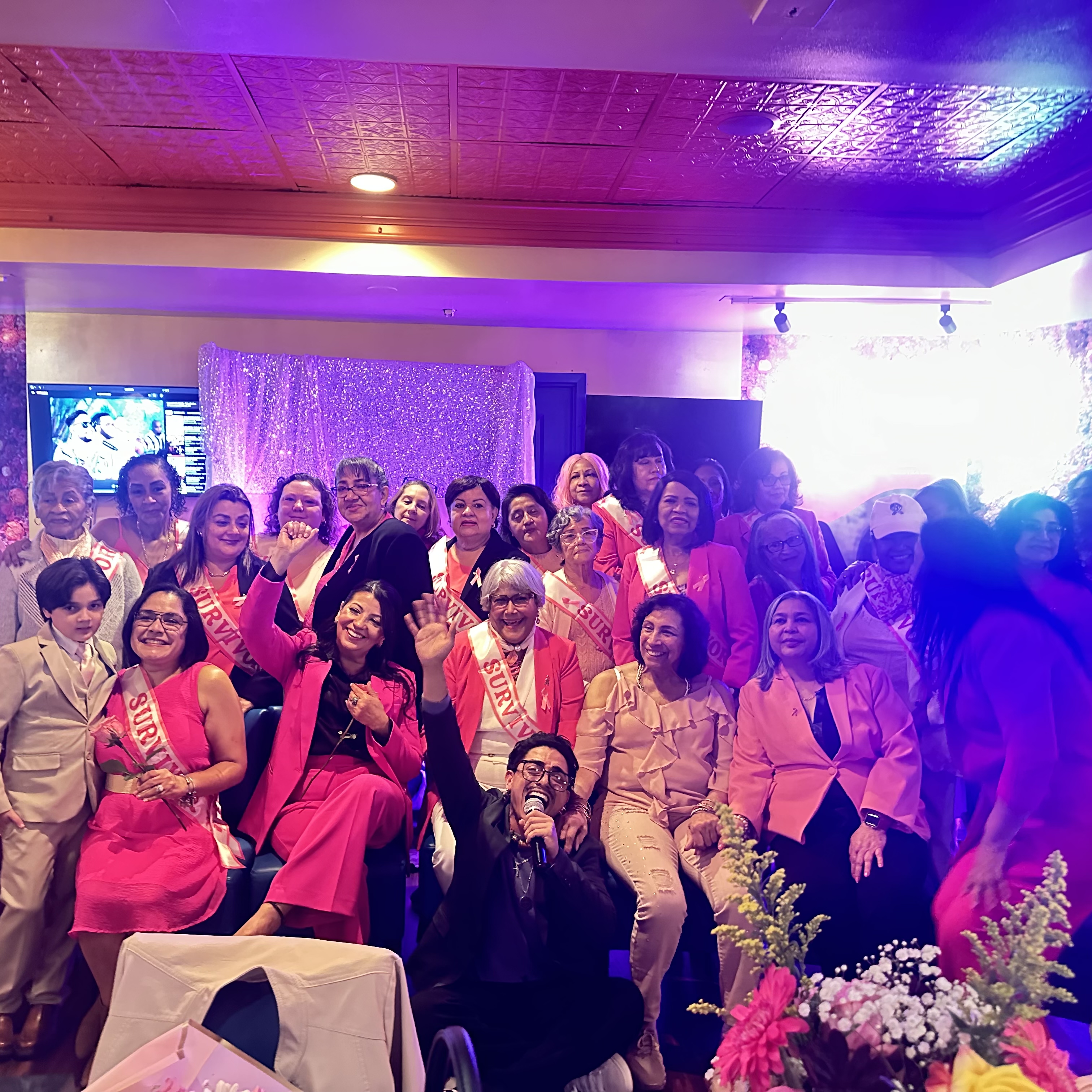 STOM cantando en la Gala Anual Mujeres Positivas Rhode Island rodeado de sobrevivientes del cáncer con bandas SURVIVOR